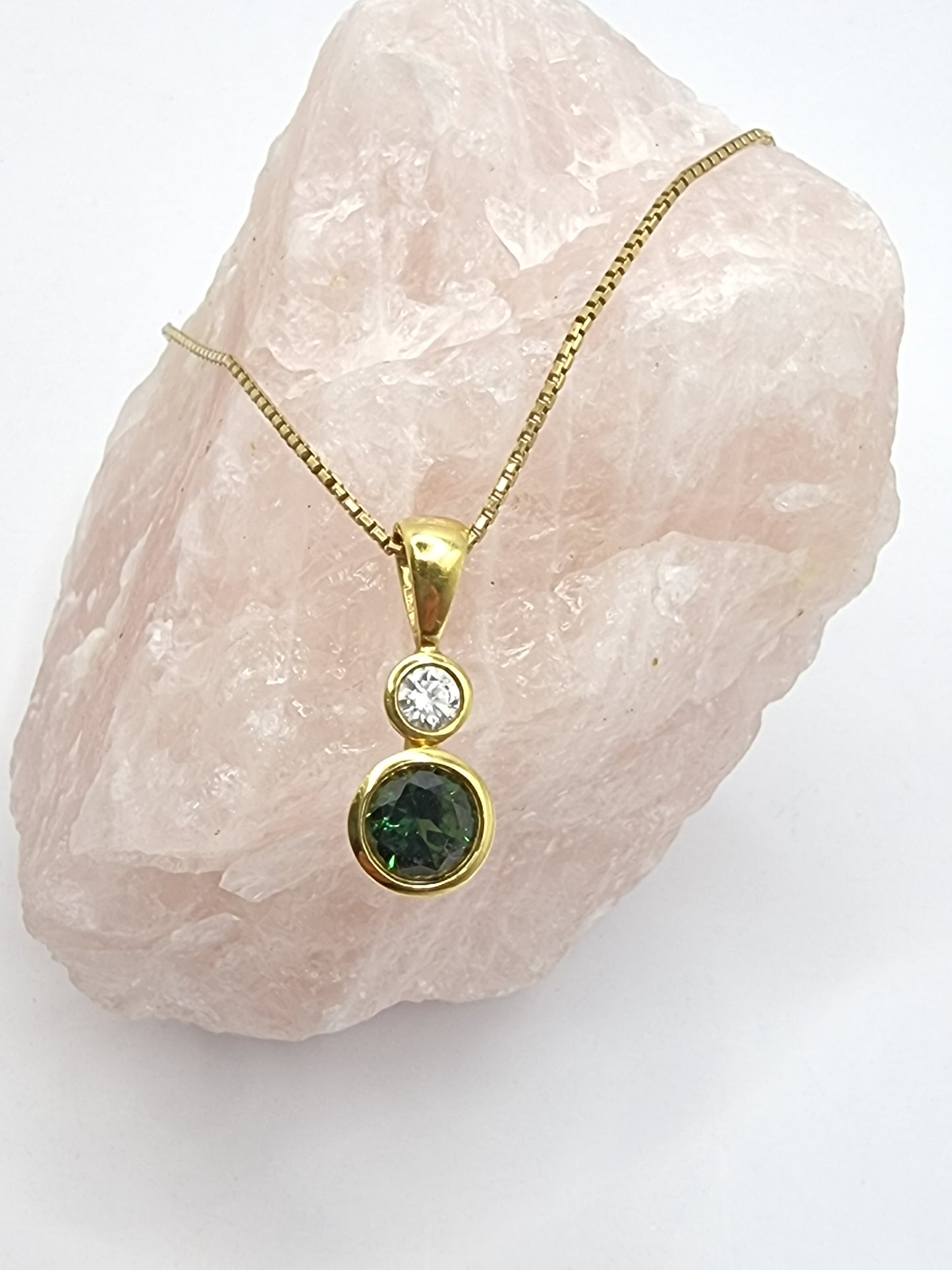 A beautiful 1.70ct round green saphire alongside a 0.27 round brilliant cut diamond